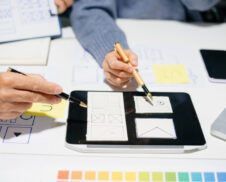 Creative UX UI team designing website wireframes, templates, and color systems with digital tools and real people in a tech office environment.